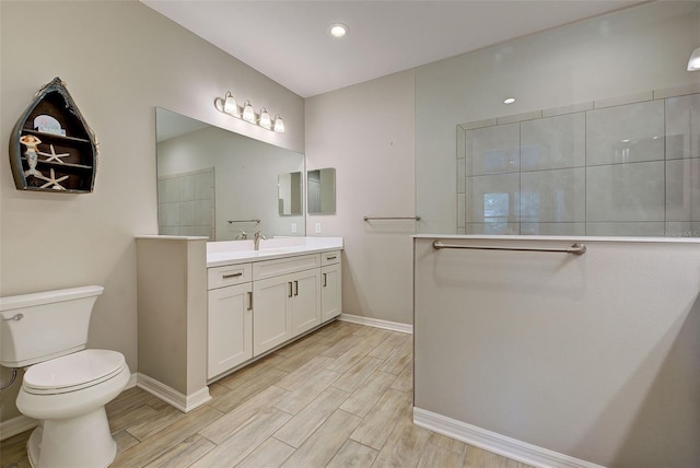 bathroom with walk in shower, vanity, and toilet