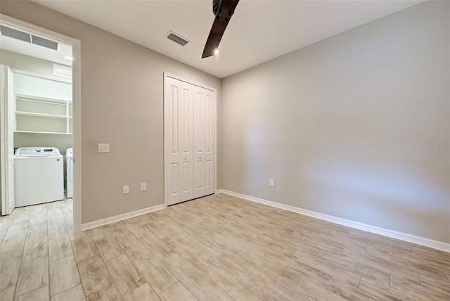 unfurnished bedroom with washer and dryer, light wood-type flooring, a closet, and ceiling fan