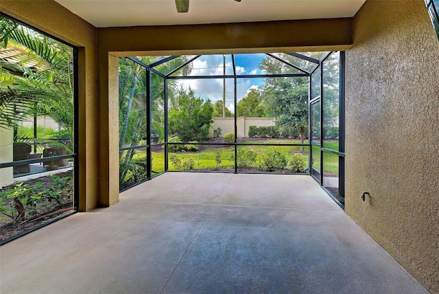 unfurnished sunroom with ceiling fan