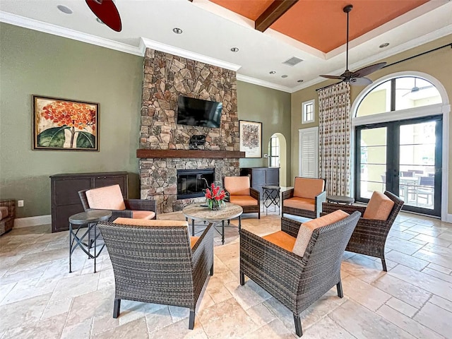 living room with ceiling fan, a fireplace, crown molding, and french doors