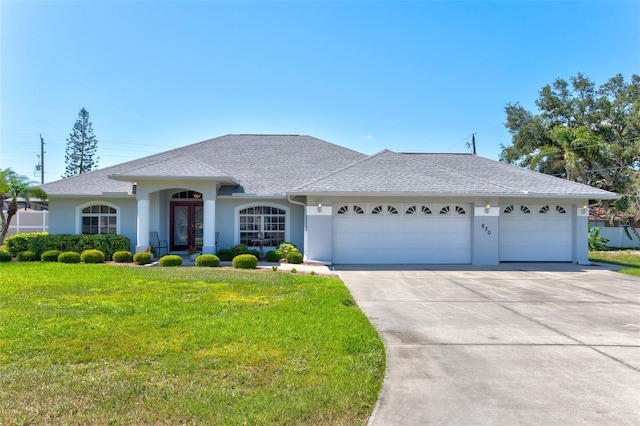 single story home featuring a garage and a front lawn