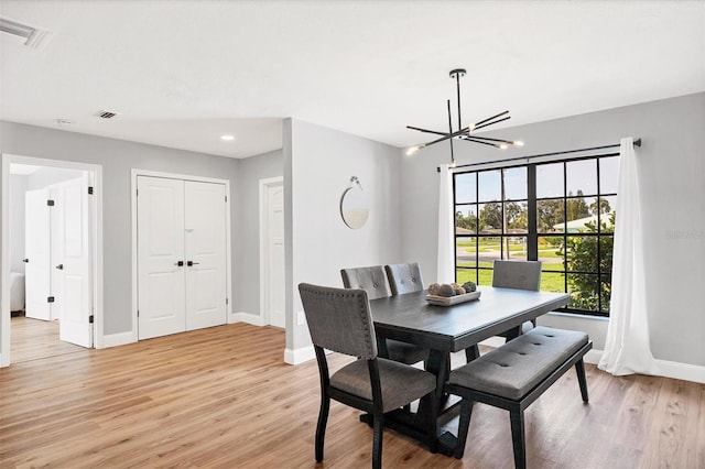 dining space with an inviting chandelier and light hardwood / wood-style floors