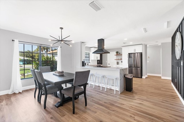 dining space featuring light hardwood / wood-style floors and an inviting chandelier