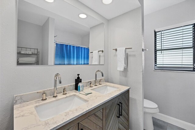 bathroom with tile patterned floors, vanity, curtained shower, and toilet