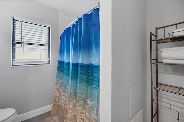 bathroom with toilet, plenty of natural light, and walk in shower