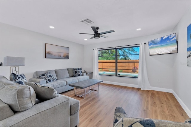 living room with ceiling fan and light hardwood / wood-style flooring