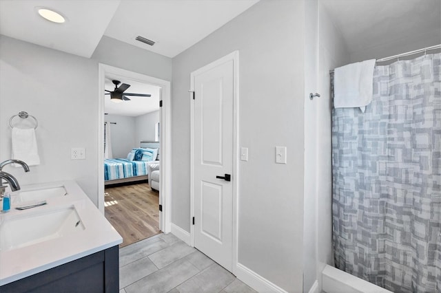 bathroom with hardwood / wood-style floors, vanity, ceiling fan, and walk in shower