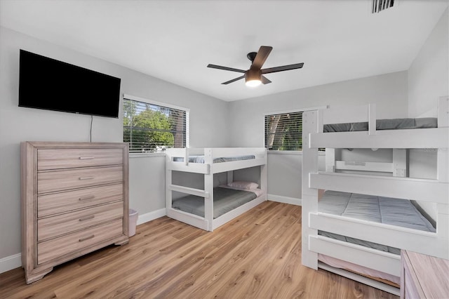 bedroom with ceiling fan, light wood-type flooring, and multiple windows