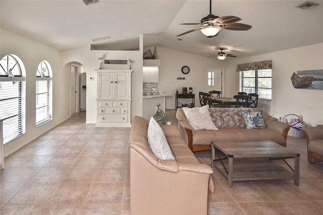 living room featuring ceiling fan, vaulted ceiling, and light tile patterned floors