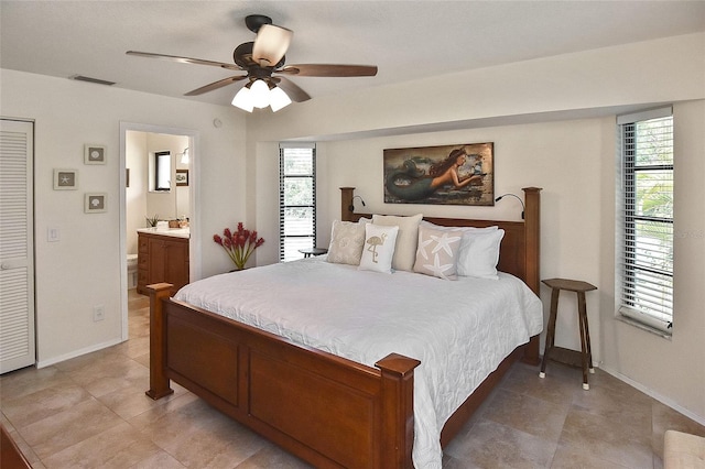 bedroom featuring multiple windows, ensuite bath, tile patterned flooring, and ceiling fan