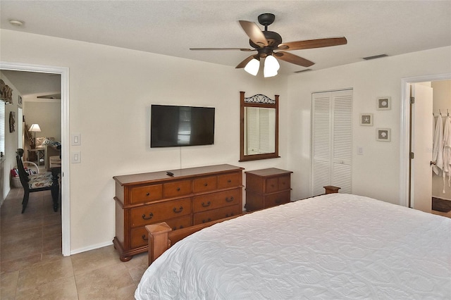 tiled bedroom featuring ceiling fan and a closet