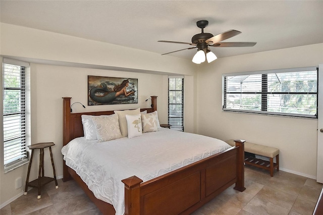 tiled bedroom featuring multiple windows and ceiling fan