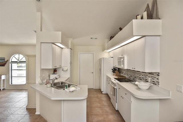 kitchen featuring white appliances, light tile patterned floors, and kitchen peninsula