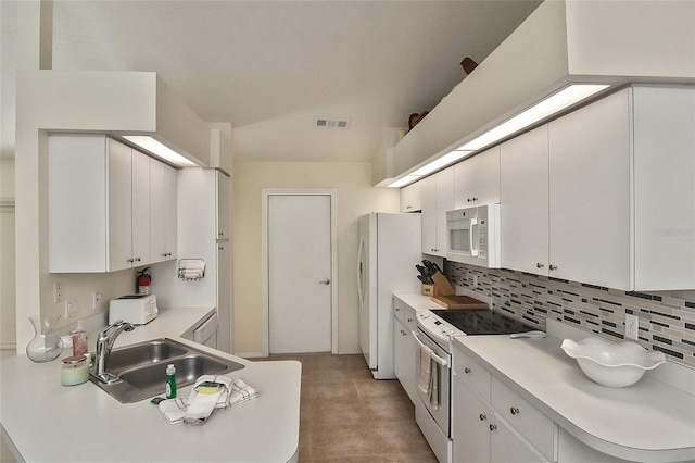 kitchen featuring sink, white appliances, and white cabinetry