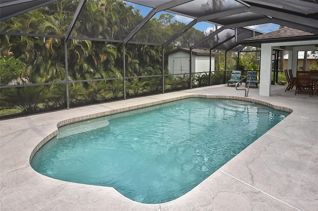 view of swimming pool featuring a patio, a storage shed, and a lanai