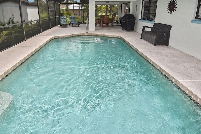 view of swimming pool with a patio area and a lanai