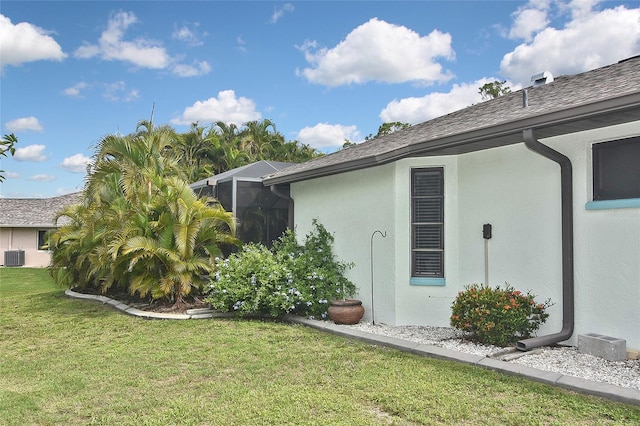 view of side of property featuring cooling unit and a lawn