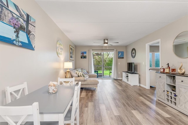 living room with ceiling fan and light hardwood / wood-style flooring