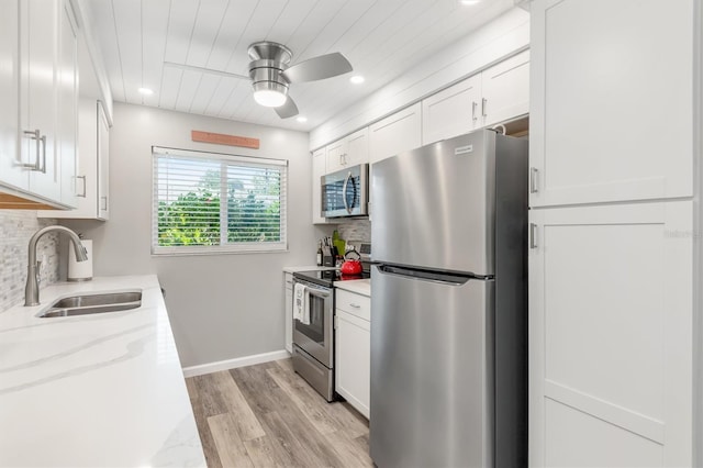 kitchen featuring tasteful backsplash, sink, stainless steel appliances, and white cabinetry