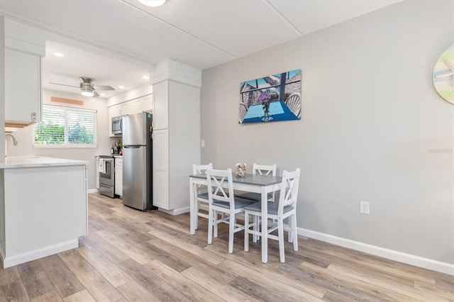 dining area with ceiling fan, sink, and light hardwood / wood-style flooring