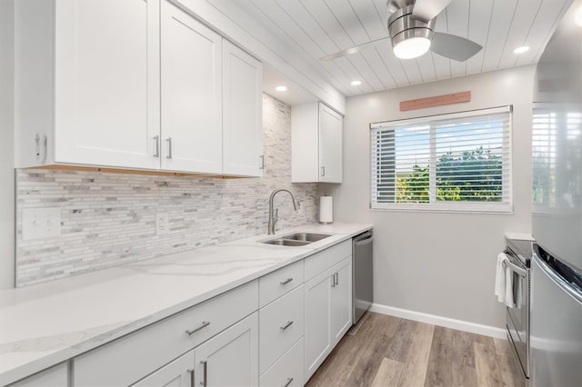 kitchen featuring light stone countertops, sink, white cabinets, and appliances with stainless steel finishes