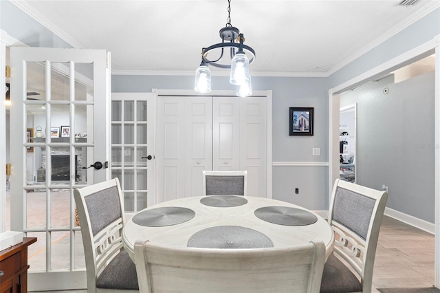 dining room with ornamental molding, hardwood / wood-style floors, and a chandelier