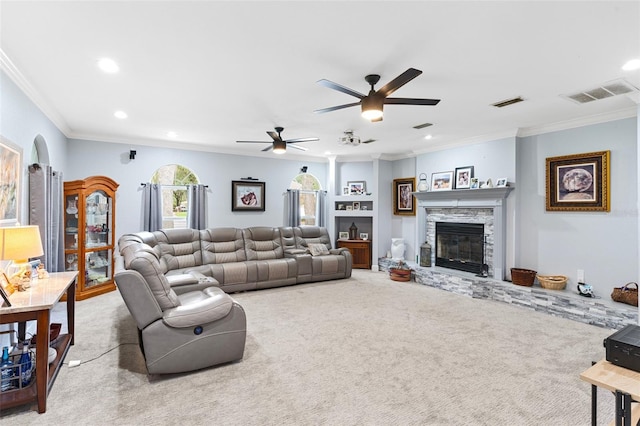 carpeted living room with crown molding, a fireplace, and ceiling fan