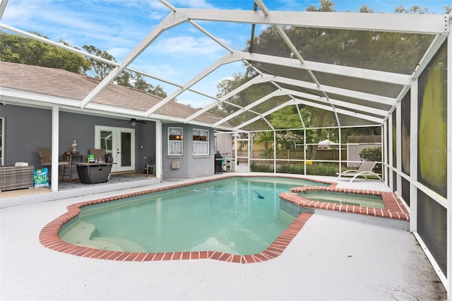 view of swimming pool featuring a patio area, a lanai, and an in ground hot tub