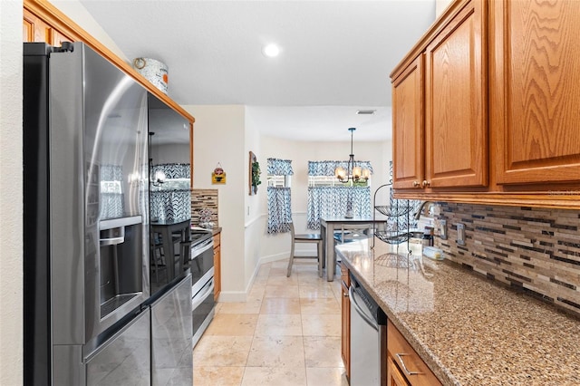 kitchen with tasteful backsplash, appliances with stainless steel finishes, stone countertops, pendant lighting, and a notable chandelier