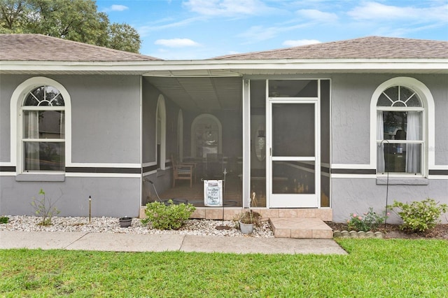 property entrance featuring a lawn