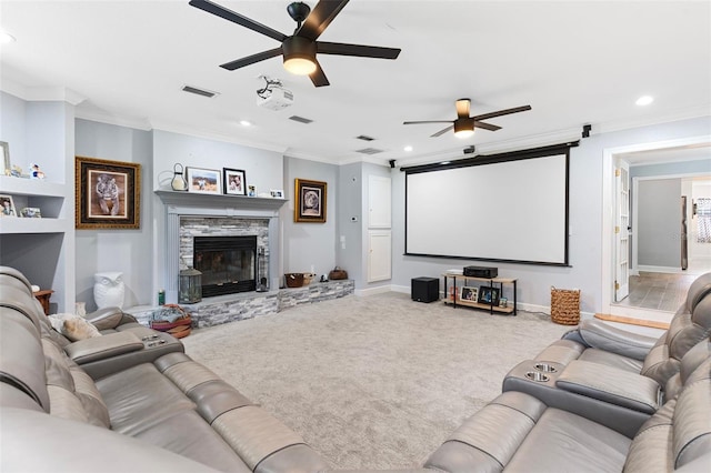 carpeted cinema featuring ceiling fan, ornamental molding, and a fireplace