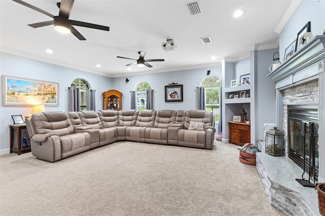 carpeted living room featuring ceiling fan, a stone fireplace, and ornamental molding