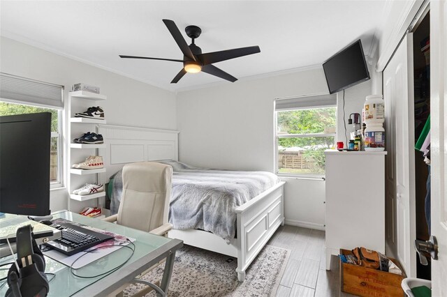 bedroom featuring a closet, ceiling fan, crown molding, and light hardwood / wood-style flooring