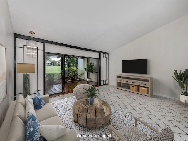 living room featuring light tile patterned flooring, an inviting chandelier, and lofted ceiling