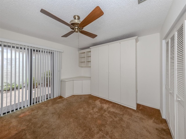 unfurnished bedroom featuring carpet, ceiling fan, and a textured ceiling