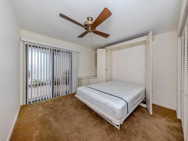 bedroom with a textured ceiling, carpet, and ceiling fan