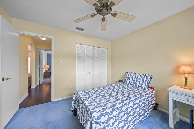 carpeted bedroom with ceiling fan and a closet