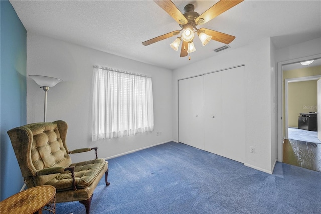 sitting room featuring ceiling fan and carpet