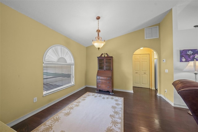 interior space with vaulted ceiling and dark hardwood / wood-style flooring