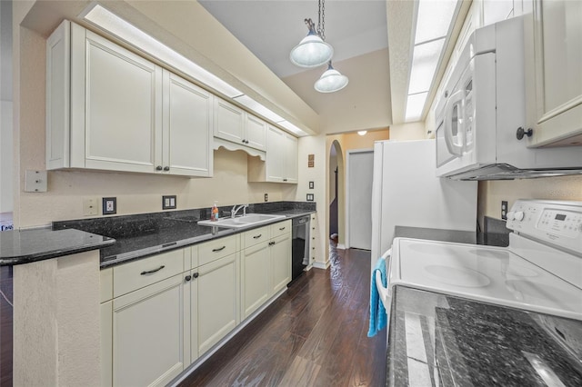 kitchen with white appliances, dark stone counters, sink, hanging light fixtures, and dark hardwood / wood-style floors