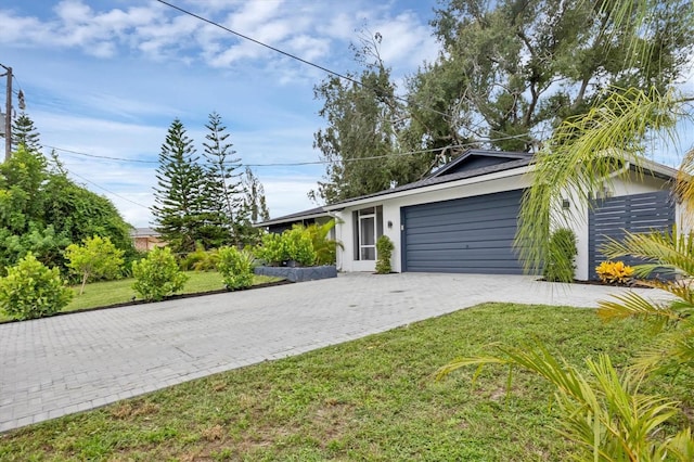 single story home with a garage and a front lawn