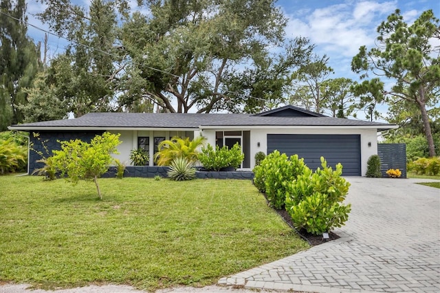 single story home with a garage and a front lawn