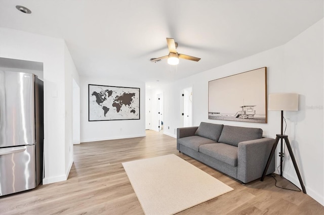 living room with light hardwood / wood-style flooring and ceiling fan