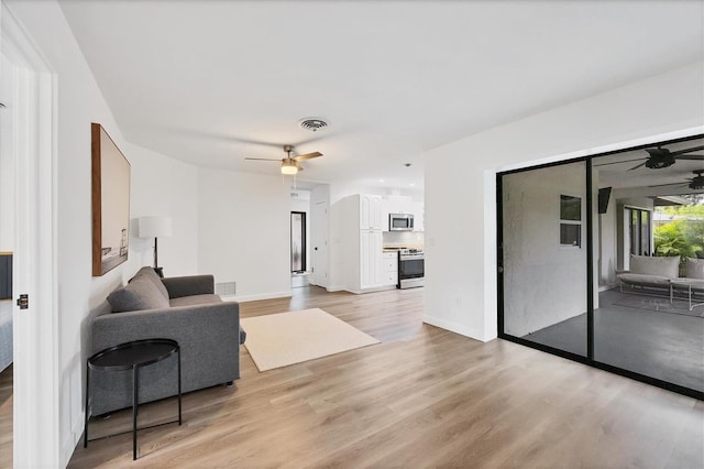 living room featuring light hardwood / wood-style floors and ceiling fan