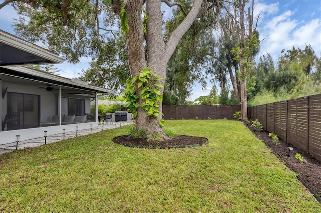 view of yard with a sunroom and ceiling fan