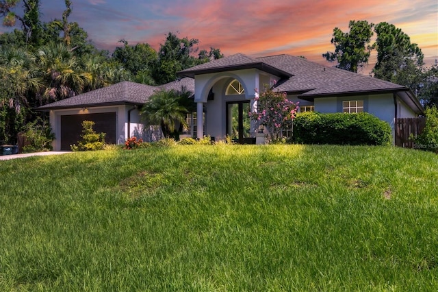 view of front facade with a garage and a lawn