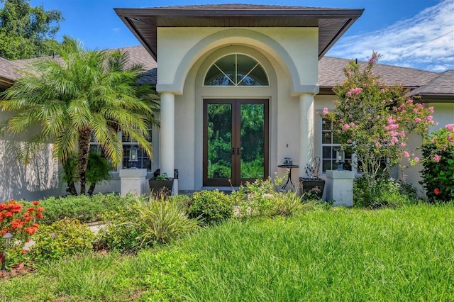 property entrance featuring a lawn and french doors