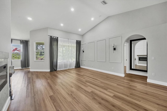 unfurnished living room featuring light hardwood / wood-style flooring and lofted ceiling