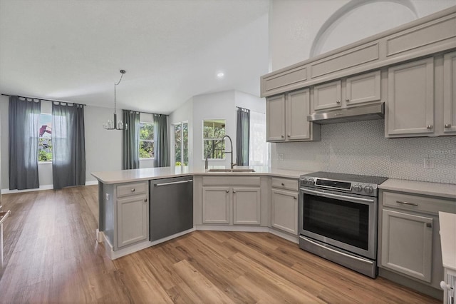 kitchen featuring vaulted ceiling, gray cabinetry, sink, kitchen peninsula, and stainless steel appliances