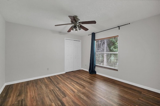 empty room with ceiling fan and dark wood-type flooring